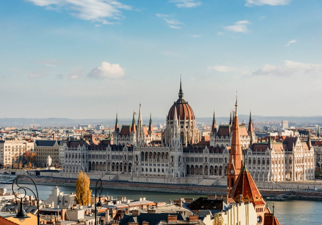 A distant view of the ornate Hungarian Parliament on a sunny day in Budapest