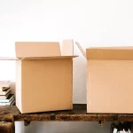 Carton boxes and stacked books on table